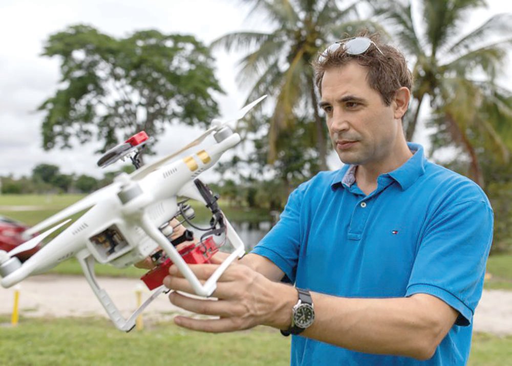 Henry Hochmair, associate professor of geomatics at Fort Lauderdale Research and Education Center, examines a research drone.